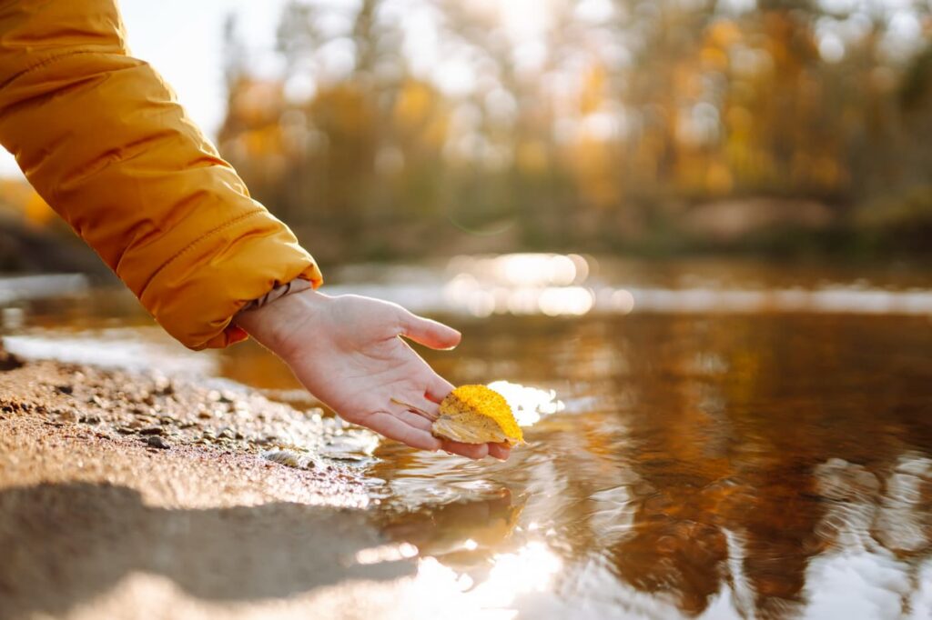 A person with their hand in a stream after receiving marijuana addiction treatment in New Jersey
